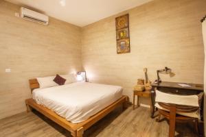 a bedroom with a bed and a desk with a lamp at Pondok Kembung Canggu in Dalung +3 photos