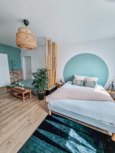 a bedroom with a large bed with a blue headboard at Le Cotil Ribes in Grangues