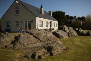 un gran grupo de rocas delante de una casa en Dunagree Bed & Breakfast en Greencastle