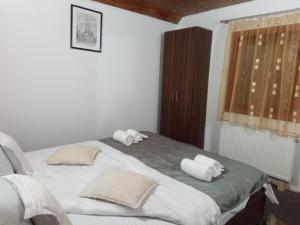a bedroom with a bed with two pillows on it at Family House in Buşteni