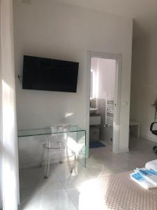 un soggiorno con tavolo in vetro e TV a parete di da Sofia a Bologna
