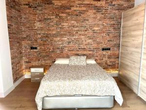 a bedroom with a brick wall and a bed at Cómodo y Moderno piso en el centro de Santander in Santander