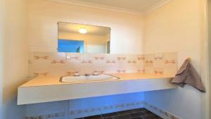 a bathroom with a sink and a mirror at Ocean Views in Burrum Heads