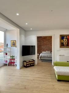 a living room with a television and a bedroom at Cómodo y Moderno piso en el centro de Santander in Santander