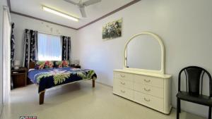 a bedroom with a bed and a mirror and a dresser at San Marco Villa Close To Beach in Burrum Heads