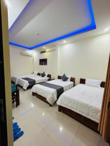 três camas num quarto com tecto azul em MyMy Motel em Da Nang