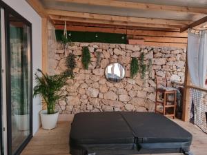 a patio with a stone wall and a black ottoman at La Vista in Drage