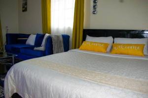 Limuru的住宿－BELEEN HOMES，一间卧室配有一张大床和一张蓝色的沙发