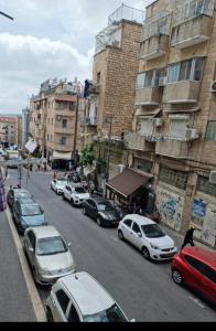een groep auto's geparkeerd in een stadsstraat bij Abi's perfect place in Jeruzalem
