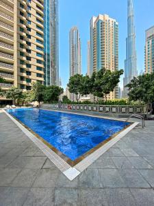 a large blue swimming pool in the middle of a city at Designer 1BR 29 Boulevard Downtown Dubai Near Burj Khalifa in Dubai