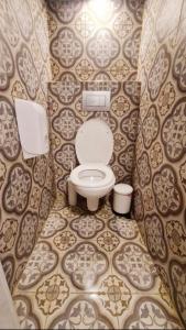 a bathroom with a toilet in a tiled room at CAPSULES & Dormitory BH in Jerusalem