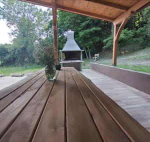 eine Holzbank unter einem Pavillon mit einem Herd in der Unterkunft Holiday home Tilia in Slatinski Drenovac