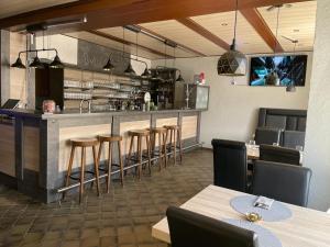un restaurant avec un bar doté de chaises et de tables dans l'établissement Hotel Roma, à Merzig
