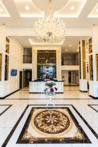 eine Lobby mit einem Kronleuchter und einem großen Teppich in der Unterkunft Frazel Heritage Hotel in Alor Setar