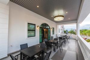 a restaurant with tables and chairs on a balcony at Frazel Heritage Hotel in Alor Setar