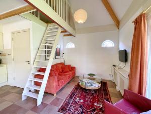 a living room with a staircase and a red couch at Uylkenshof safaritenten en natuurhuisjes in Epe