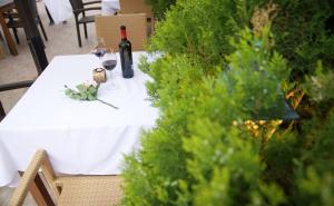 un tavolo con una bottiglia di vino e bicchieri di Hotel Sany a Primorsko