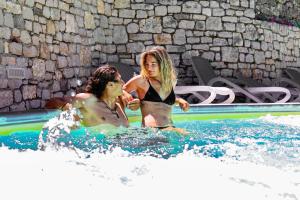 Zwei Frauen spielen im Wasser im Pool in der Unterkunft Agricampeggio Paradiso in Brenzone sul Garda