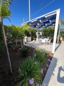une terrasse avec une pergola bleue et blanche. dans l'établissement Villetta Azzurra, à Alcamo Marina