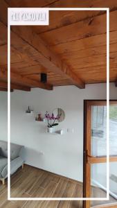 Habitación con techo de madera y puerta de cristal. en Pri Piskovih, en Grgar