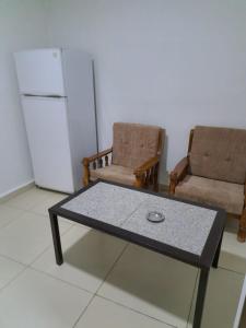 sala de estar con mesa de centro y 2 sillas en Omaima Hotel Apartments, en Amán
