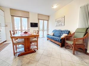 een woonkamer met een bank, een tafel en stoelen bij Casa Alpina - Appartamento Aosta in Aosta