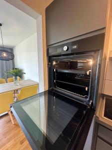 uma cozinha com um forno preto num quarto em Beautiful 2-room apartment with balkony in Willich em Willich