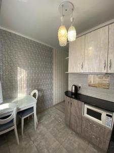 a kitchen with a table and a dining room at VIP квартира в Центре, 2 комнаты in Kostanay
