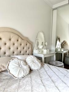 a bedroom with a bed with pillows and a mirror at New Town Classic Apartments SELF-CHECK IN in Vilnius