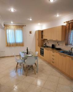 cocina con mesa y sillas y cocina con fregadero en Central Moudros apartments, en Moúdhros