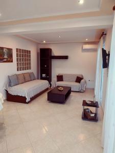 a bedroom with two beds and a table in it at Central Moudros apartments in Moúdhros