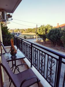 a balcony with a table and chairs and a view of a river at Central Moudros apartments in Moúdhros