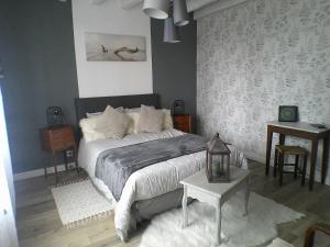 a bedroom with a large bed and a table at LE CLOCOONING in Billy