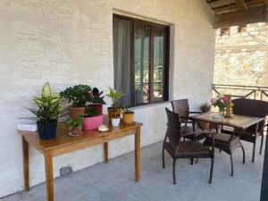 eine Terrasse mit einem Tisch, Stühlen und Pflanzen in der Unterkunft GUEST HOUSE ,, MEMORY'' in Mestia