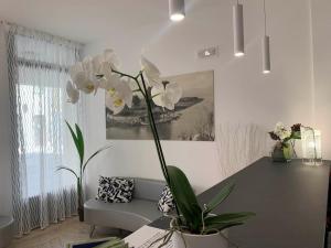 - un salon avec un canapé et une table ornée de fleurs blanches dans l'établissement Euro Meublé, à Grado