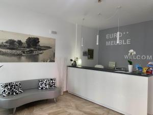 a lobby with a reception desk and a bench at Euro Meublé in Grado