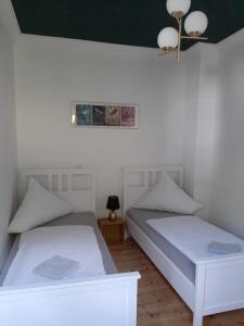 two beds in a room with white walls at Art Deco Villa Bacharach in Bacharach