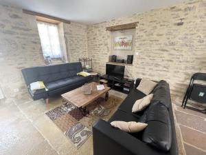 sala de estar con sofá y mesa en L'Ouvrée, chaleureux en famille ou entre amis, en Saint-Aubin