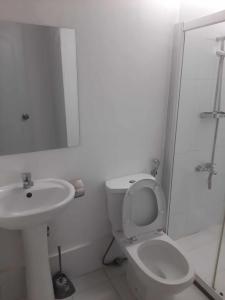 Cebu City Apple One Banawa Heights في مدينة سيبو: حمام ابيض مع مرحاض ومغسلة
