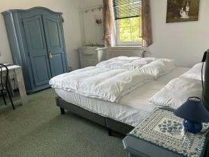 een slaapkamer met een bed en een blauwe kast bij Altenmedinger Hof in Altenmedingen