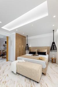 a white bedroom with a large bed and a couch at Olvos Suite in Naxos Chora