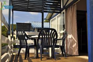 twee stoelen en een tafel op een veranda met een parasol bij Camping Ampurdanes in Roses