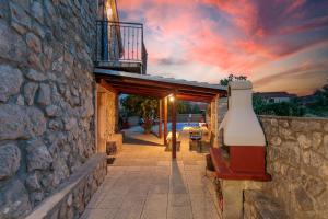 a stone building with a bench and a sunset at Villa Galovic in Brzac