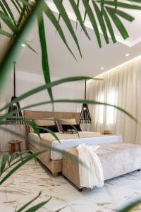 a bedroom with two beds and a plant at Olvos Suite in Naxos Chora