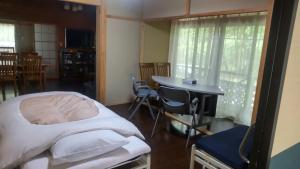 sypialnia z łóżkiem, stołem i krzesłami w obiekcie 貸別荘「ブライト那須」 w mieście Nasu