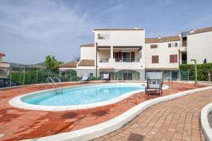 a swimming pool in front of a house at Soleluna apartment in Castelsardo