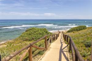un sentiero per la spiaggia con l'oceano sullo sfondo di Soleluna apartment a Castelsardo