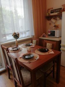a dining room table with four chairs and a microwave at Apartman Classic in Komárno