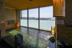 a large indoor swimming pool with a view of the water at Dormy Inn PREMIUM Kushiro in Kushiro