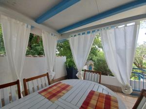 a bedroom with a white table and a window at Holiday Home Adricon in Grižane